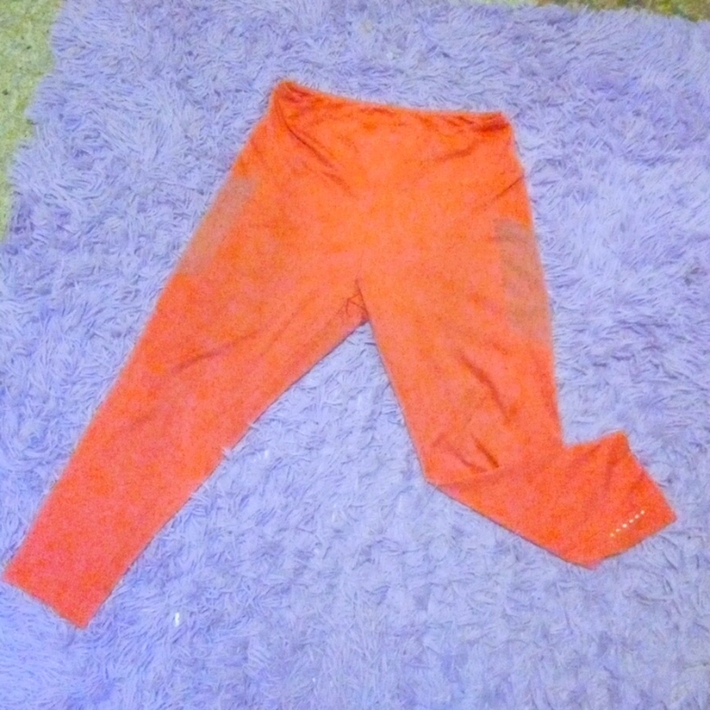 Sporty woman's orangy-red leggings good for sports, walks, hiking, and more.